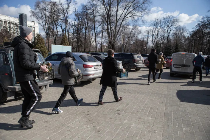 Localat a park in Dnipro, Ukraine, carry crates of bottles.