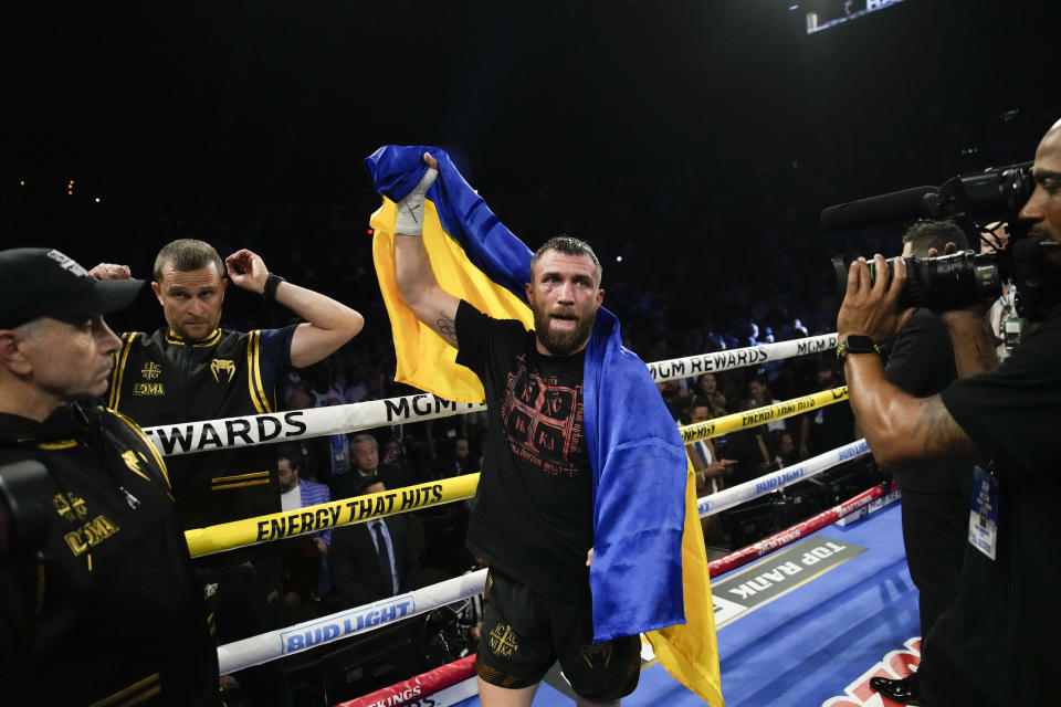 Vasiliy Lomachenko holds up his Ukrainian flag after an undisputed lightweight championship boxing match against Devin Haney Saturday, May 20, 2023, in Las Vegas. Haney won by unanimous decision. (AP Photo/John Locher)