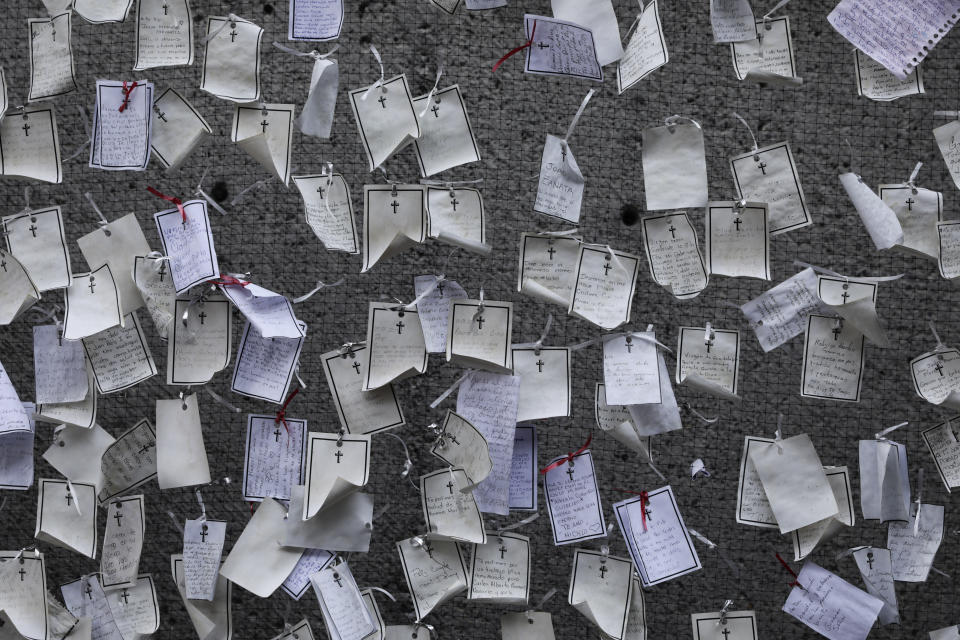 Messages written by loved ones and dedicated to the deceased hang from a wall at a memorial for COVID-19 victims installed outside the Basilica of Guadalupe in Mexico City, Wednesday, April 14, 2021. (AP Photo/Eduardo Verdugo)