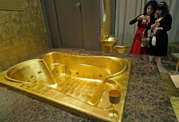 Guests take snapshots of a gold bathtub at the 2006 Millionaires' Fair at the Shanghai Exhibition Center April 28, 2006.