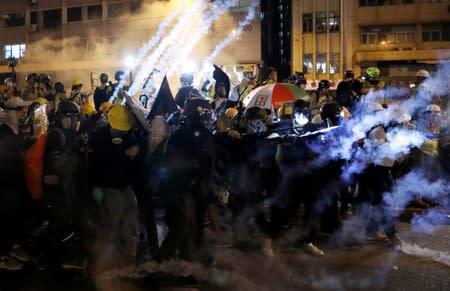 An anti-extradition demonstrators have tear gas fired at them as they clash with riot police, after a march of to call for democratic reforms, in Hong Kong