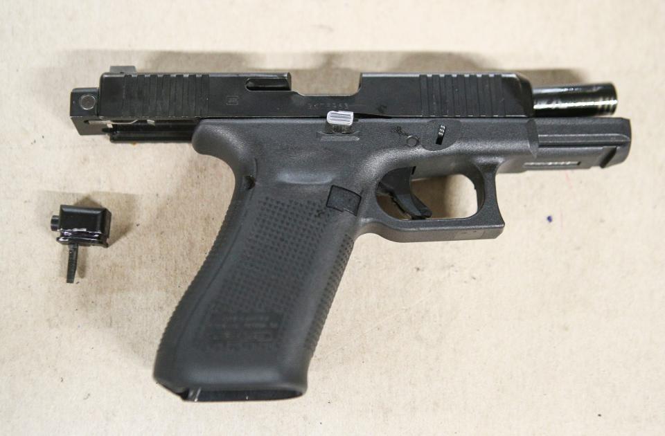 A Glock pistol with an illegal conversion device, sometimes referred to as a "Glock switch." The small piece, which is illegal and not manufactured by Glock, can convert a semi-automatic pistol into a fully automatic one.