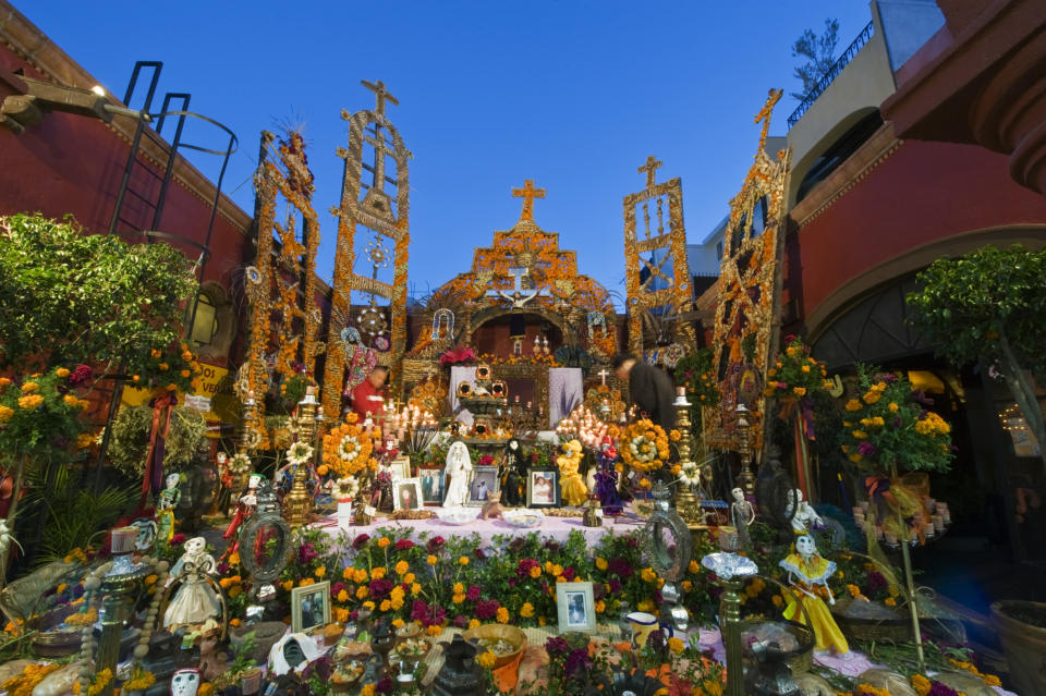 A vibrant Day of the Dead altar decorated with marigolds, candles, and various offerings