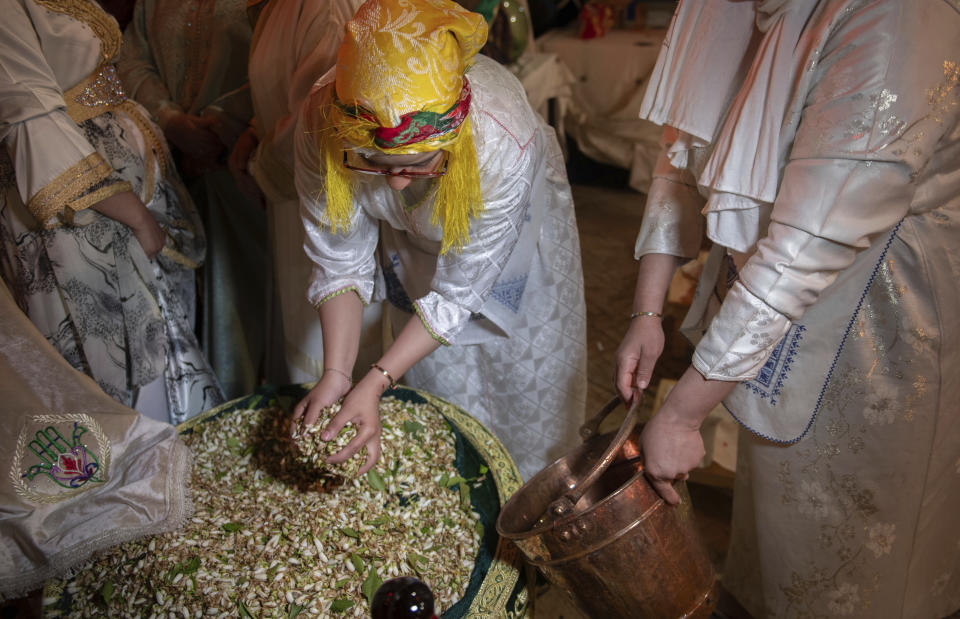 Women prepare to distill orange blossoms in a cultural center in Marrakech, Morocco, Saturday, March 23, 2024. Moroccan cities are heralding in this year's spring with orange blossoms by distilling them using traditional methods. Orange blossom water is mostly used in Moroccan pastries or mint tea and sprinkled over heads and hands in religious ceremonies. (AP Photo/Mosa'ab Elshamy)