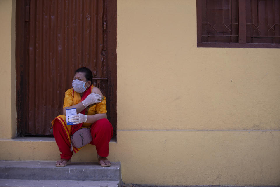 A Nepalese woman sits after getting inoculated against the coronavirus in Kathmandu, Nepal, Tuesday, June 8, 2021. Nepal resumed its stalled coronavirus vaccination campaign on Tuesday with 1 million doses given by China after the Himalayan nation made international pleas for help with a shortage of doses. (AP Photos/Bikram Rai)