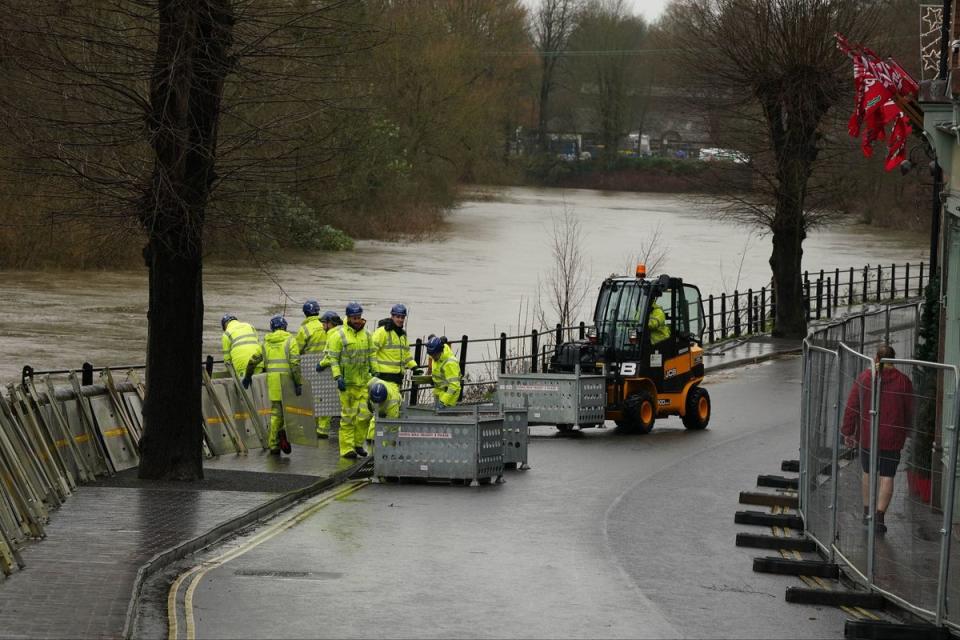 The swollen River Severn as flood defenses are put in place along the wharfage at Ironbridge in Telford (PA)