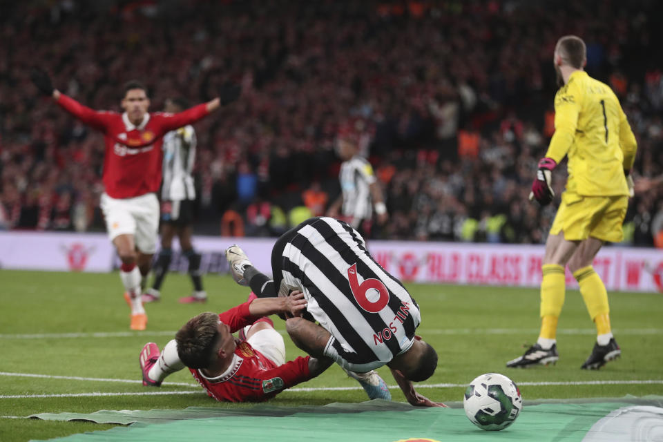 Manchester United's Lisandro Martinez, left, is challenged by Newcastle's Callum Wilson during the English League Cup final soccer match between Manchester United and Newcastle United at Wembley Stadium in London, Sunday, Feb. 26, 2023. (AP Photo/Scott Heppell)