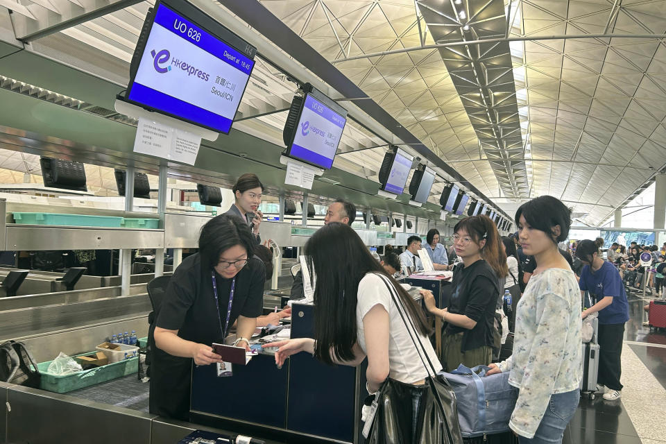 Passengers line up for manual check-in at the Hong Kong International Airport during a global technology outage in Hong Kong, Friday, July 19, 2024. (AP Photo/Kanis Leung)