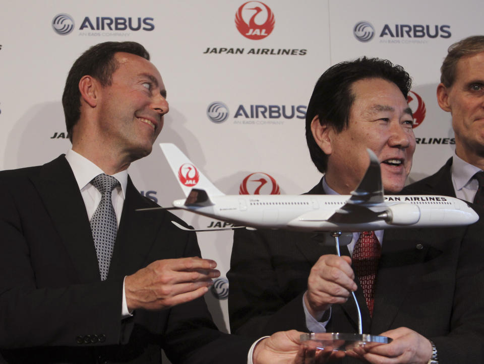 Airbus Japan Chief Executive Fabrice Bregier, left, and Japan Airlines President Yoshiharu Ueki, right, hold a model plane of Airbus A350 following their press conference in Tokyo, Monday, Oct. 7, 2013. Japan Airlines is buying its first ever jets from Airbus in a deal with a catalog value of 950 billion yen ($9.5 billion) with a purchase of 31 A350 planes. (AP Photo/Junji Kurokawa)