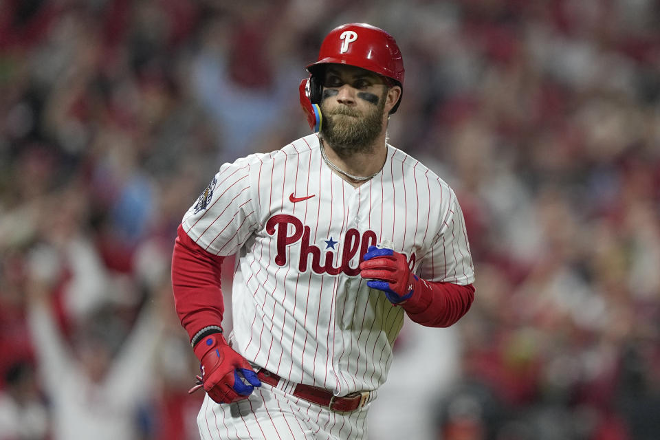 FILE - Philadelphia Phillies' Bryce Harper celebrates his two-run home run during the first inning in Game 3 of baseball's World Series between the Houston Astros and the Philadelphia Phillies on Tuesday, Nov. 1, 2022, in Philadelphia. Harper’s arrival at spring training camp remains a couple of weeks away as the Philadelphia Phillies slugger recovers from offseason elbow surgery. (AP Photo/David J. Phillip, File)