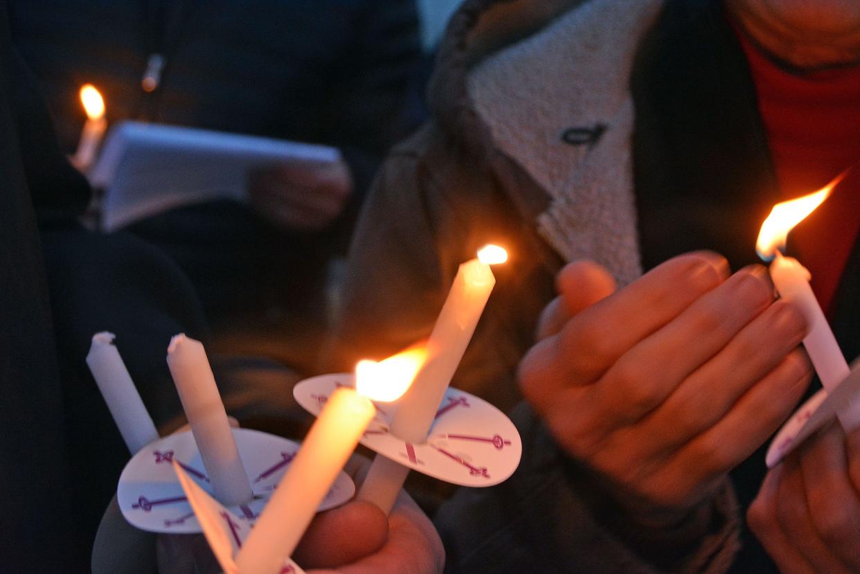 Candle light is shared among guests Thursday at a memorial service from the Salvation Army Harbor House in Columbia for the city's unsheltered residents who died in 2023.