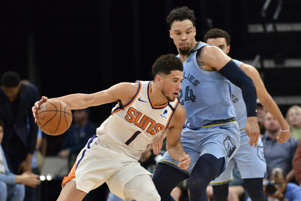 Phoenix Suns guard Devin Booker (1) handles the ball against Memphis Grizzlies guard Dillon Brooks (24) in the first half of an NBA basketball game Sunday, Jan. 26, 2020, in Memphis, Tenn. (AP Photo/Brandon Dill)