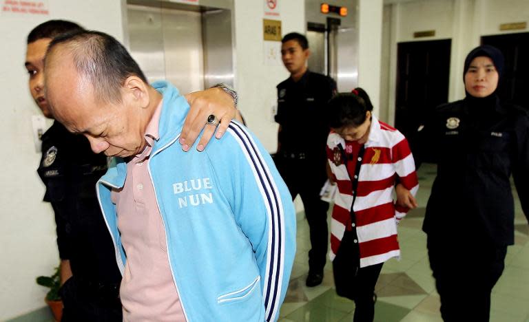 Police escort Fong Kong Meng, 58, (front R) and his wife Teoh Ching Yen, 56, (back C) at the Malaysian high court in Shah Alam, outside Kuala Lumpur after they were sentenced to death for killing their Indonesian maid