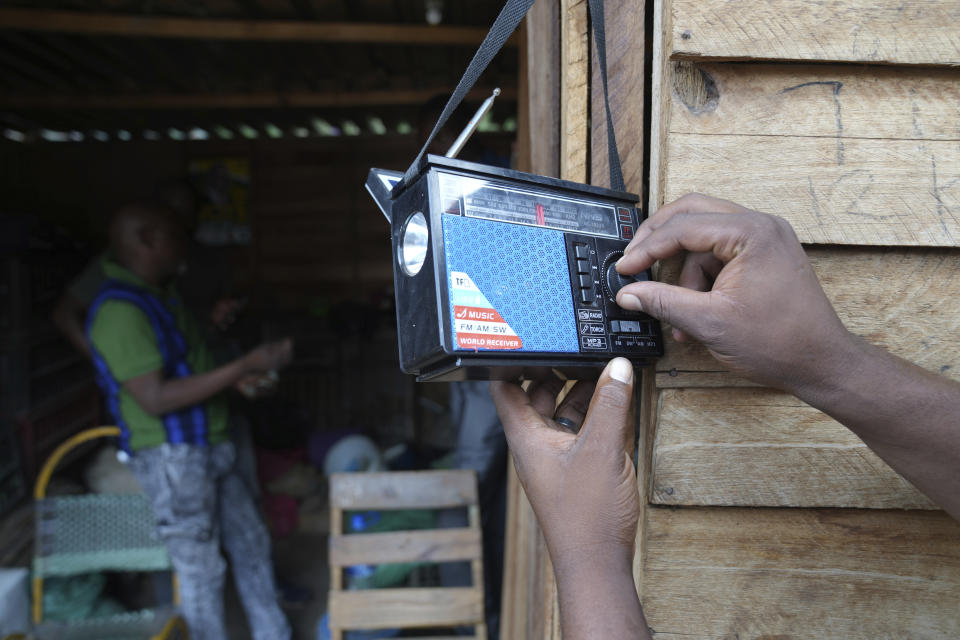 A man tunes a small radio set to listen to news at a busy local marketplace stall in Harare, Thursday, Feb. 2, 2023. According to a survey by Afrobarometer, radio is “overwhelmingly” the most common source of news in Africa. About 68% of respondents said they tune in at least a few times a week, compared to about 40% who said they use social media and the internet. (AP Photo/Tsvangirayi Mukwazhi)