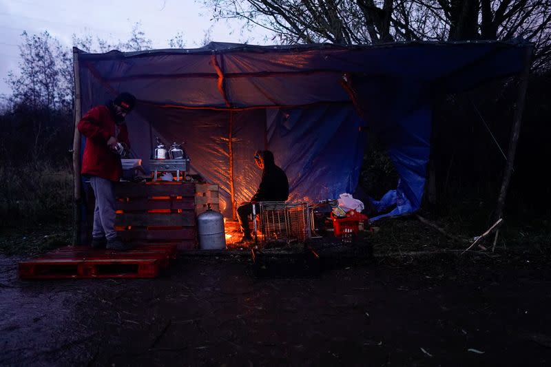 Wider Image: En un campo de inmigrantes en Francia, un hombre vende sándwiches para pagarle a los traficantes