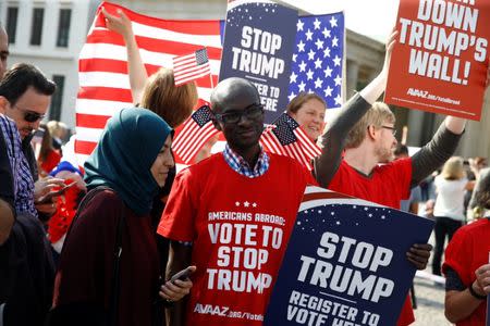 Campaigners pose with 'Stop Trump' signs in front of the Brandenburg Gate to urge Americans living abroad to register and vote in Berlin, Germany, September 23, 2016. REUTERS/Axel Schmidt