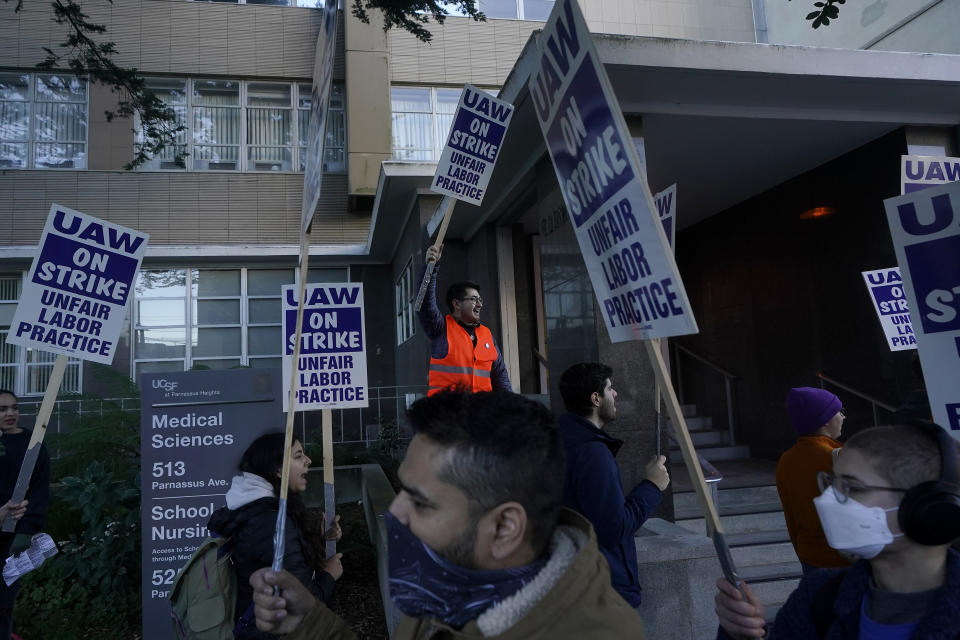 Nick Mroz, graduate student at the University of California San Francisco, middle rear, takes part in a protest outside of UCSF medical offices in San Francisco, Monday, Nov. 14, 2022. Nearly 48,000 unionized academic workers at all 10 University of California campuses have walked off the job Monday. (AP Photo/Jeff Chiu)