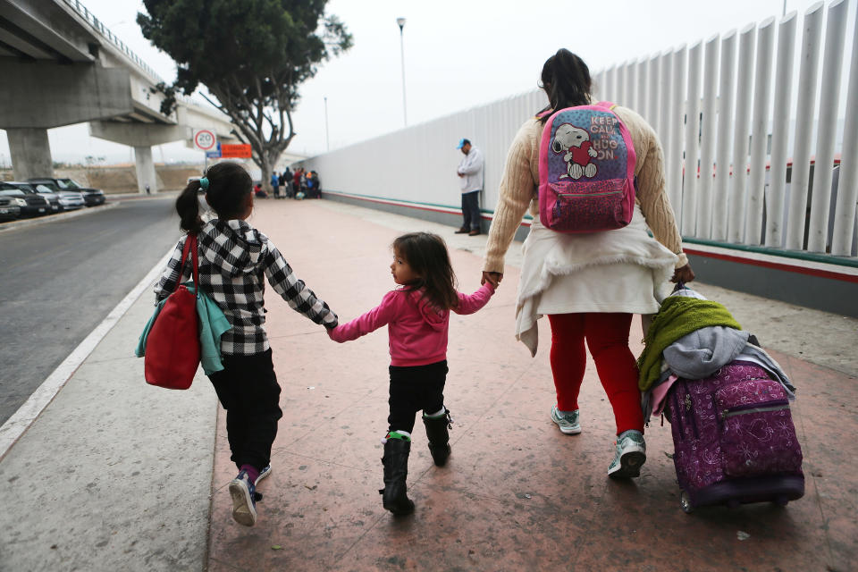 <p>A migrant mother walks with her two daughters on their way to cross the port of entry into the U.S. for their asylum hearing in Tijuana, Mexico. The mother, who did not wish to give their names, said they were fleeing their hometown near the Pacific coast of Mexico after suffering a violent carjacking of her taxicab. The Trump Administration’s controversial zero tolerance immigration policy led to an increase in the number of migrant children who have been separated from their families at the southern U.S. border. U.S. Attorney General Jeff Sessions has added that domestic and gang violence in immigrants’ country of origin would no longer qualify them for political asylum status. (Mario Tama/Getty Images) </p>