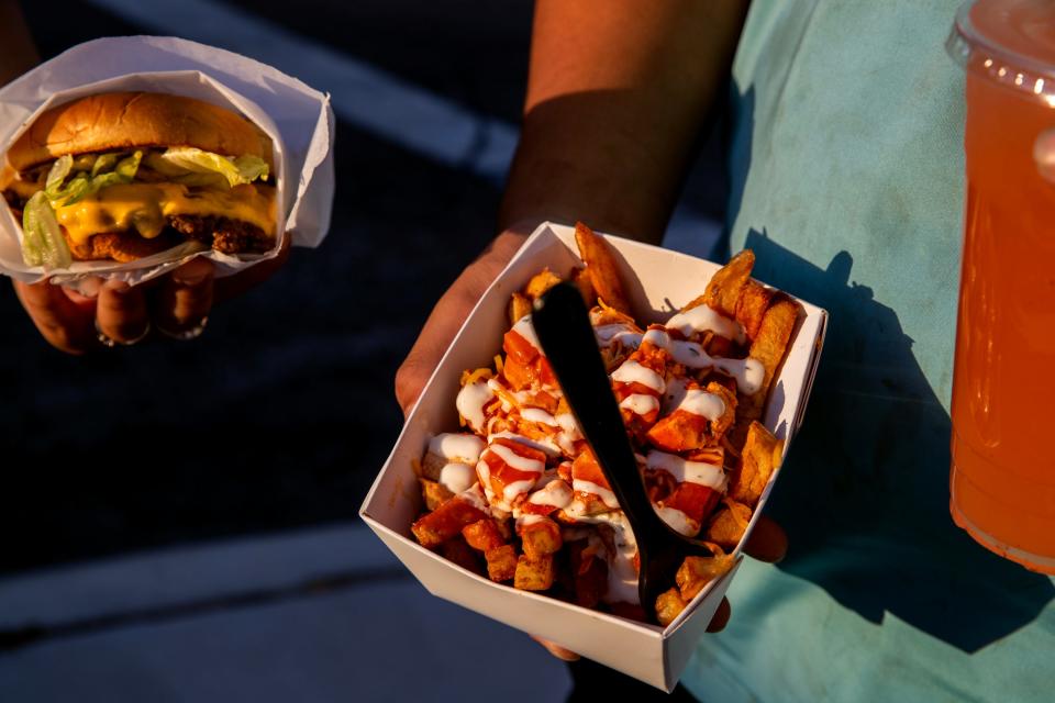 People carry food purchased from one of the several food trucks on Palm Drive and Pierson Boulevard during Friday Nights on Pierson, held every Friday in Desert Hot Springs, in downtown Desert Hot Springs, Calif., on Friday, May 12, 2023.