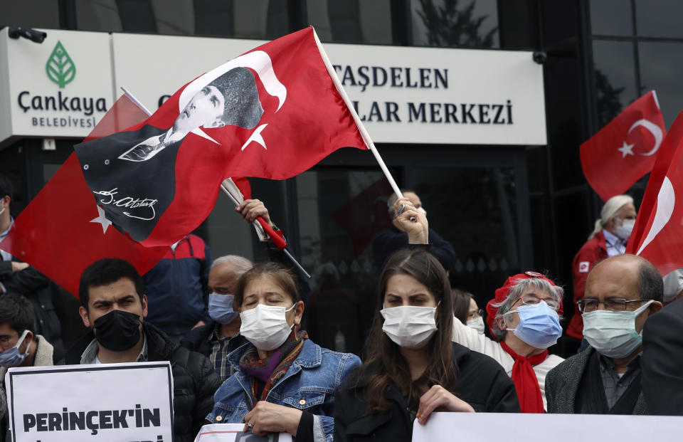 People wearing masks to help protect against the spread of coronavirus, attend a protest outside the US embassy, in Ankara, Turkey, Monday, April 26, 2021. Turkey's President Recep Tayyip Erdogan has announced the country's strictest pandemic restrictions so far, closing businesses and schools and limiting travel for nearly three weeks starting Thursday to fight a surge in COVID-19 infections and deaths. (AP Photo/Burhan Ozbilici)