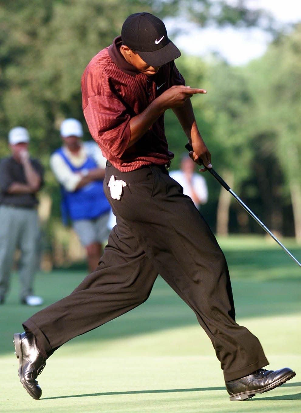 Tiger Woods coaxes the ball into the hole on the sixteenth green during the playoff at Valhalla.- 