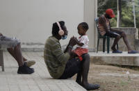 A Haitian migrant, hoping to reach the U.S.-Mexico border, spends one-on-one time with a child at the Jesus Esta Vivo shelter in Danli, Honduras, Wednesday, Sept. 22, 2021. (AP Photo/Elmer Martinez)