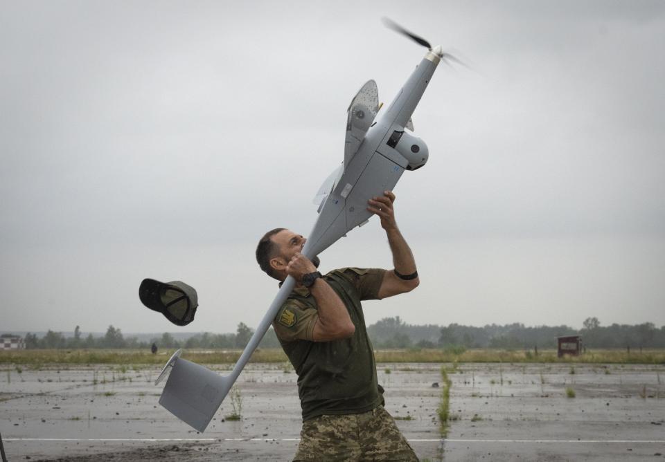FILE - A Ukrainian soldier launches FlyEye WB Electronics SA, a Polish reconnaissance drone, which is in service with the Ukrainian army, in Kyiv region, Ukraine, Tuesday, Aug. 2, 2022. A spate of drone attacks that Russian authorities blamed on Ukraine has targeted areas in southern and western Russia, reflecting the Ukrainian military's growing reach as the war dragged into a second year. (AP Photo/Efrem Lukatsky, File)