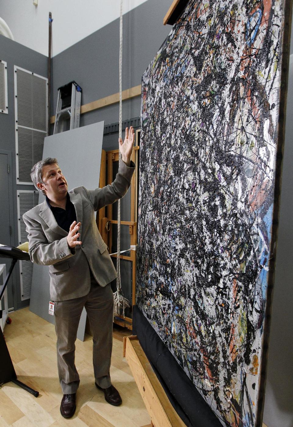 Nicholas Dorman, chief conservator for the Seattle Art Museum, talks about his on-going restoration work of Jackson Pollock's painting Sea Change during a news conference Tuesday, Nov. 27, 2012, at the museum in Seattle. The celebrated piece, part of SAM's permanent collection, was painted in 1947 and altered in 1970 with a coat of varnish. Dorman is several months into the restoration work, which is complicated by the uneven surface and multiple layers of media, including several types of paint and imbedded gravel. The restoration is sponsored by Bank of America's Art Conservation Project, which enabled SAM staff and consulting experts to undertake a study of the original materials and evaluate the impact of materials used in conservation treatments. (AP Photo/Elaine Thompson)