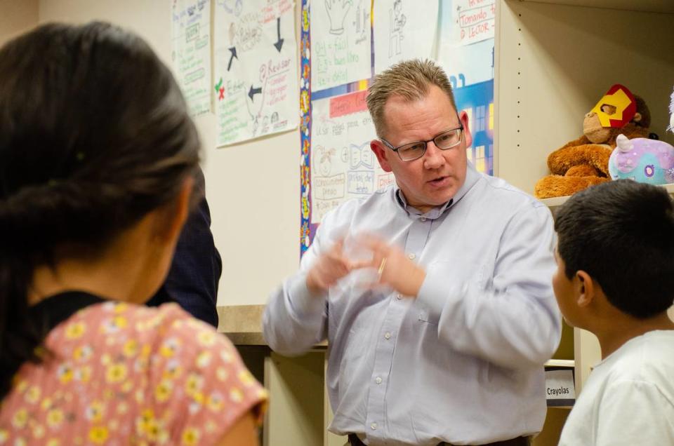 Washington State Superintendent Chris Reykdal speaks to a bilingual fourth grader in 2022 during a visit to McClintock STEM Elementary School in Pasco.