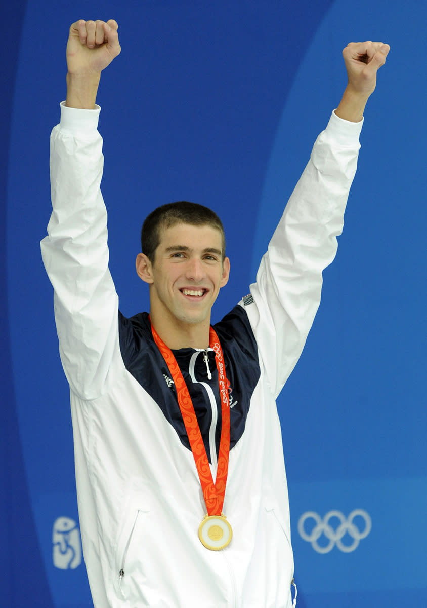 <p>Michael Phelps with his gold medal after winning the 100m butterfly final at the Beijing 2008 Olympic Games on August 16, 2008. It was with this prize that Phelps tied Mark Spitz’s record of winning seven gold medals in a single Olympic Games. (Bob Thomas/Getty Images)</p>
