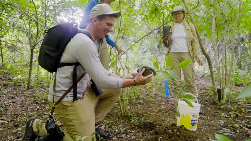 Bill planta un árbol en nombre de sus hijos, River y Olivia, en Colombia en 2023. - Julián Quiñones/CNN