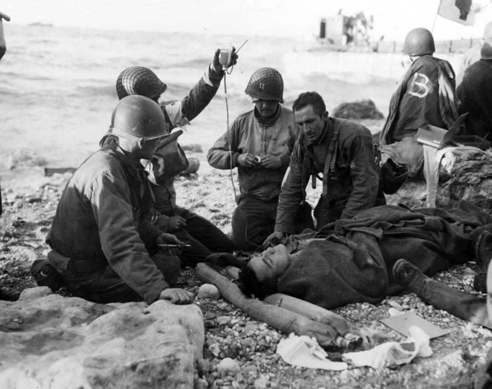 U.S. Army medical personnel administer a plasma transfusion to a wounded comrade, who survived when his landing craft went down off the coast of Normandy, France, in the early days of the Allied landing operations in June 1944. On D-Day, Charles Shay was a 19-year-old Native American army medic who was ready to give his life — and actually saved many. Now 99, he's spreading a message of peace with tireless dedication as he's about to take part in the 80th celebrations of the landings in Normandy that led to the liberation of France and Europe from Nazi Germany occupation. (AP Photo, File)