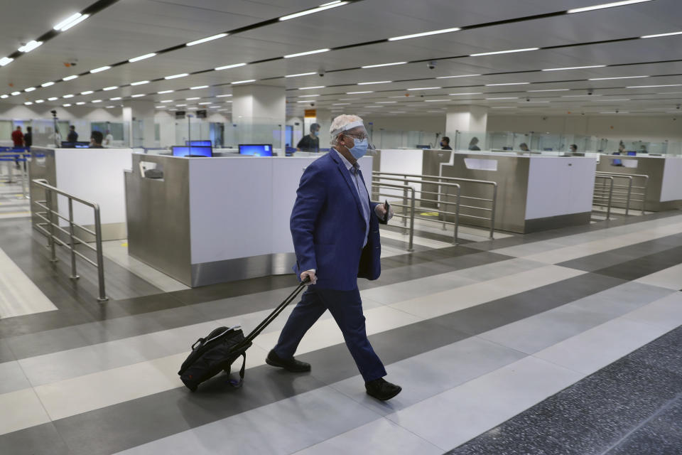 A passenger arrives at the Rafik Hariri International Airport in Beirut, Lebanon, Wednesday, July 1, 2020. Beirut's airport is partially reopening after a three-month shutdown and Lebanon's cash-strapped government is hoping that thousands of Lebanese expatriates will return for the summer, injecting dollars into the country's sinking economy. (AP Photo/Bilal Hussein)