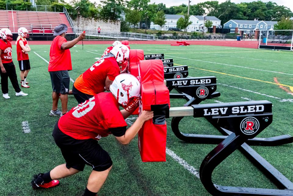The New Bedford defensive line works with the sled at training.