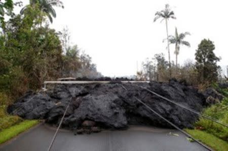 Lava and downed power lines block a road in the Leilani Estates subdivision during ongoing eruptions of the Kilauea Volcano, Hawaii, U.S., May 8, 2018. REUTERS/Terray Sylvester