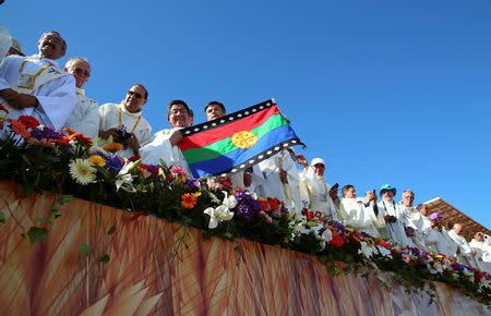 A priest holds a Mapuche flag as Pope Francis arrives to lead a mass at the Maquehue Temuco Air Force base in Temuco, Chile, January 17, 2018. REUTERS/Alessandro Bianchi