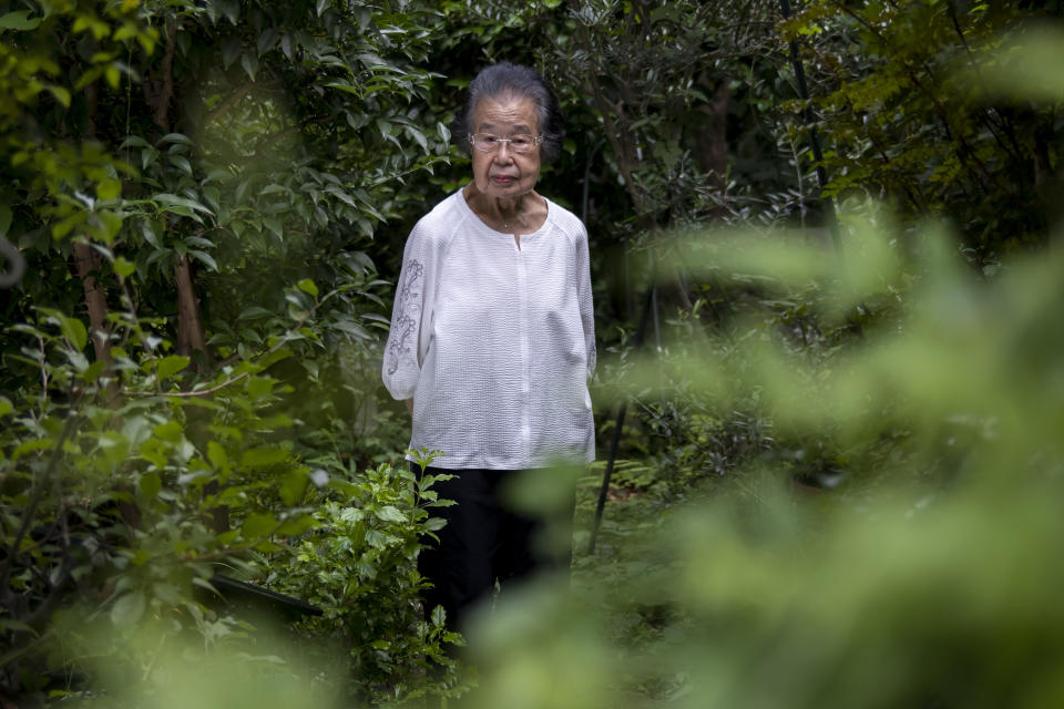 Fumie Sato poses for picture in her backyard Saturday, Aug. 1, 2020, at her home in Yokohama, Japan. Hours after she heard Emperor Hirohito's Aug. 15 radio speech declaring Japan's defeat at her school ground in Manchuria, China, Sato had to be prepared for honorable suicide with her family, though her father decided his family must live. Two years later she almost became an orphan when her little sister died of illness after their mother and little brother took an earlier boat back to Japan. (AP Photo/Kiichiro Sato)