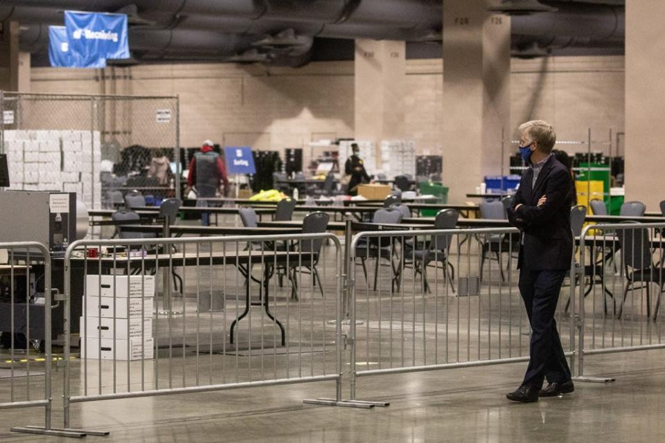 A man watches from the observers area as election workers count ballots at the Philadelphia Convention Center on Nov. 6 in Pennsylvania.