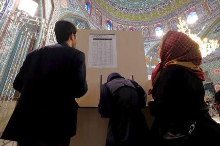 Iranians look at a list of candidates' names during elections for the parliament and Assembly of Experts, which has the power to appoint and dismiss the supreme leader, at a polling station in Tehran February 26, 2016. REUTERS/Raheb Homavandi/TIMA