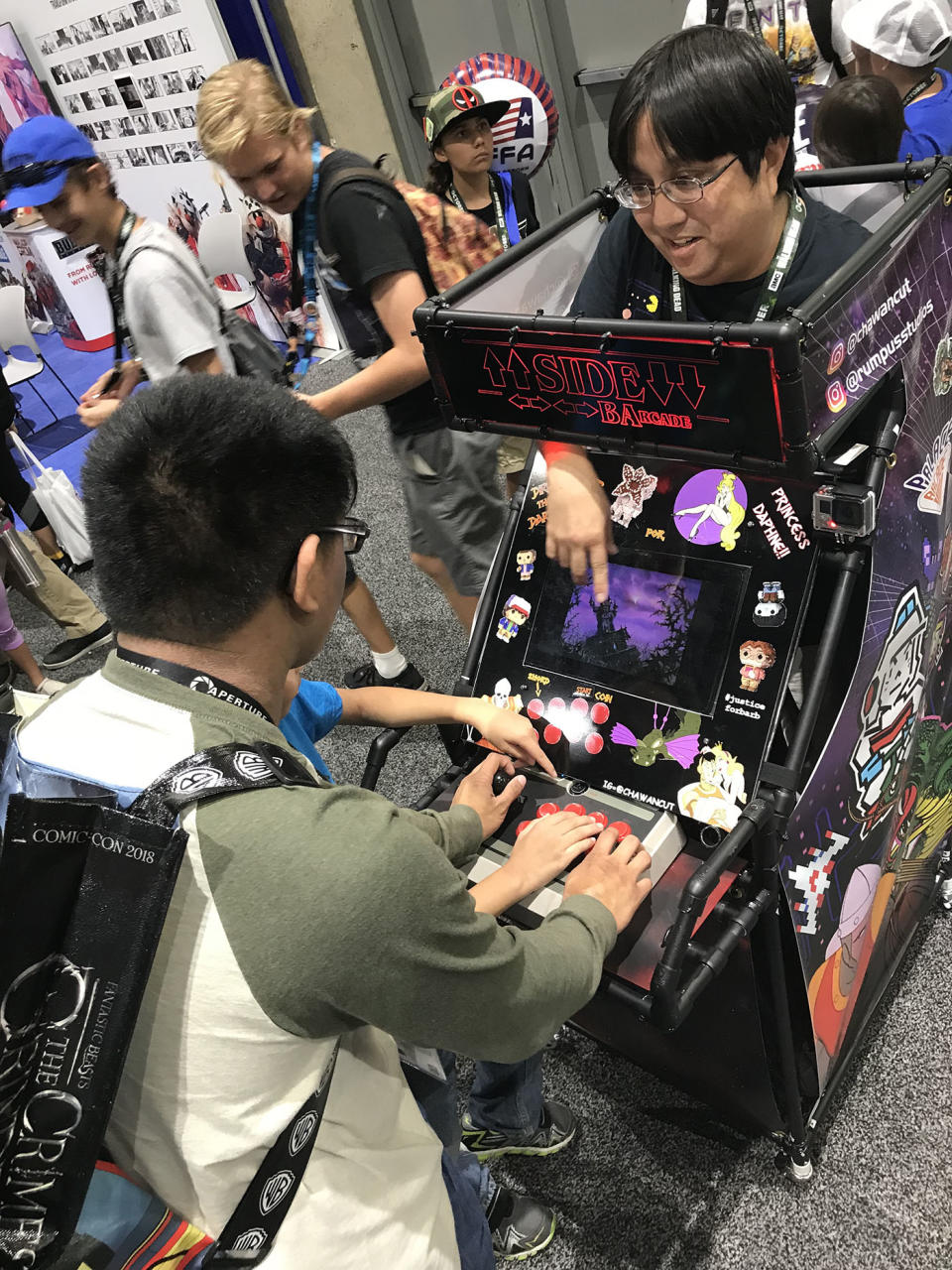 Keith Takeda shows someone how to play <em>Dragon’s Lair</em> at San Diego Comic-Con. (Photo: Angela Kim/Yahoo Entertainment)