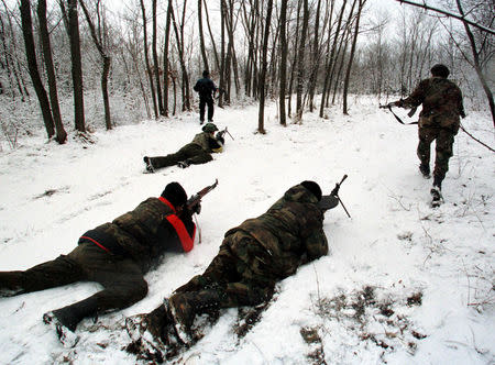 FILE PHOTO: Kosovo Liberation Army (KLA) guerrillas advance to take positions at a forest west of Podujevo some 30 km north of Kosovo's provincial capital Pristina, January 28. REUTERS/Yannis Behrakis/File photo