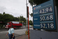 A commuter walks past a huge sign of the new pump prices of gasoline and diesel following its implementation Tuesday, Sept. 17, 2019, in suburban Valenzuela city north of Manila, Philippines. Monday saw another round of oil price increase in the country which energy officials said is not related to the recent attacks in Saudi Arabia but has cautioned the public to brace for more spikes in the coming days. (AP Photo/Bullit Marquez)