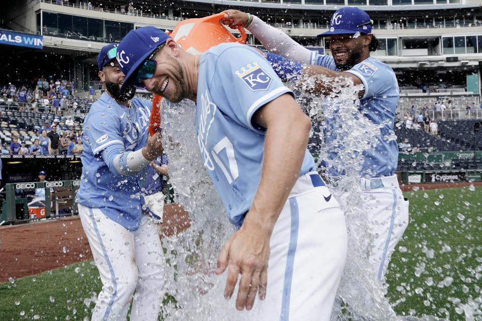 Kansas City Royals' Hunter Dozier (17) is doused with water by Emmanuel Rivera, left, and MJ Melendez as they celebrate a win over the Tampa Bay Rays during a baseball game Sunday, July 24, 2022, in Kansas City, Mo. (AP Photo/Ed Zurga)
