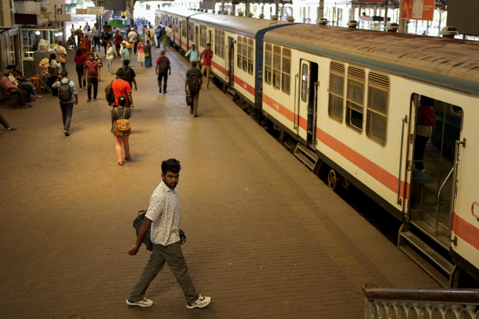 Passengers walk on a platform next to a train during a railway union strike in Colombo, Sri Lanka, Wednesday, July 10, 2024. (AP Photo/Eranga Jayawardena)