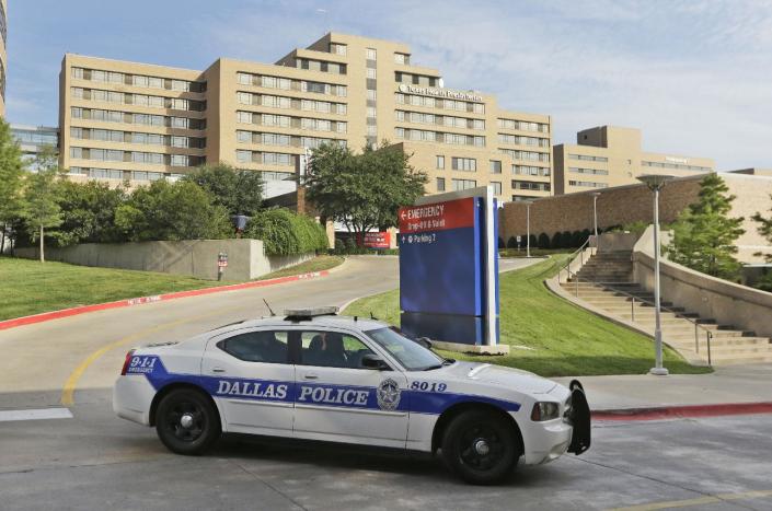 A police car drives past the entrance to the Texas Health Presbyterian Hospital in Dallas. (AP Photo/LM Otero)