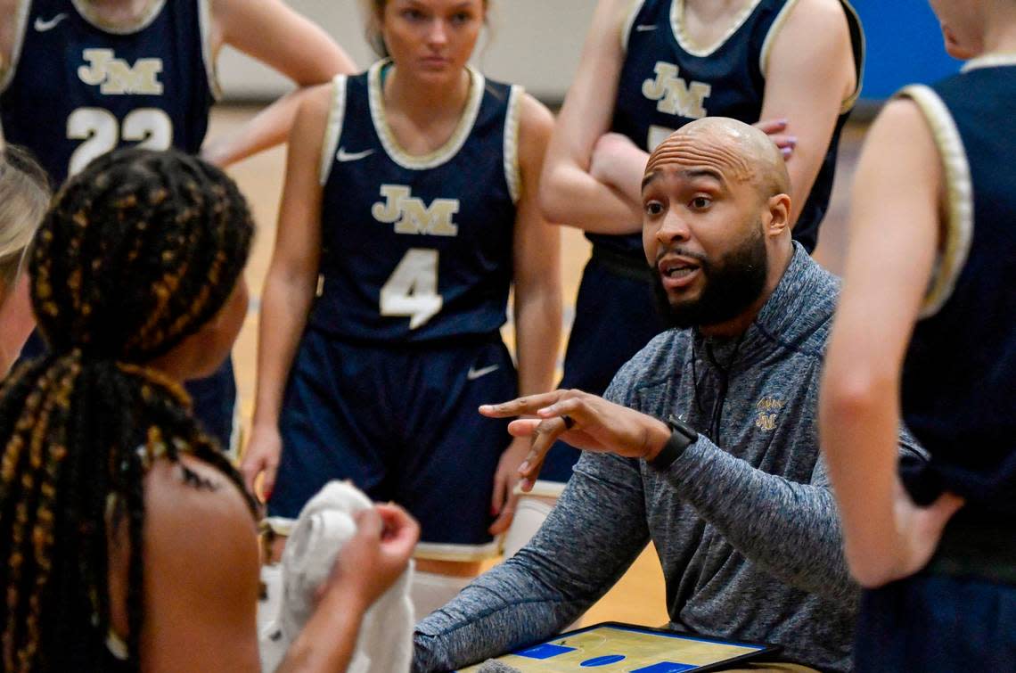 John Milledge coach Jeremy Mayweather speaks with his team during a timeout of the Trojans’ 57-47 win over FPD in their region tournament Thursday.