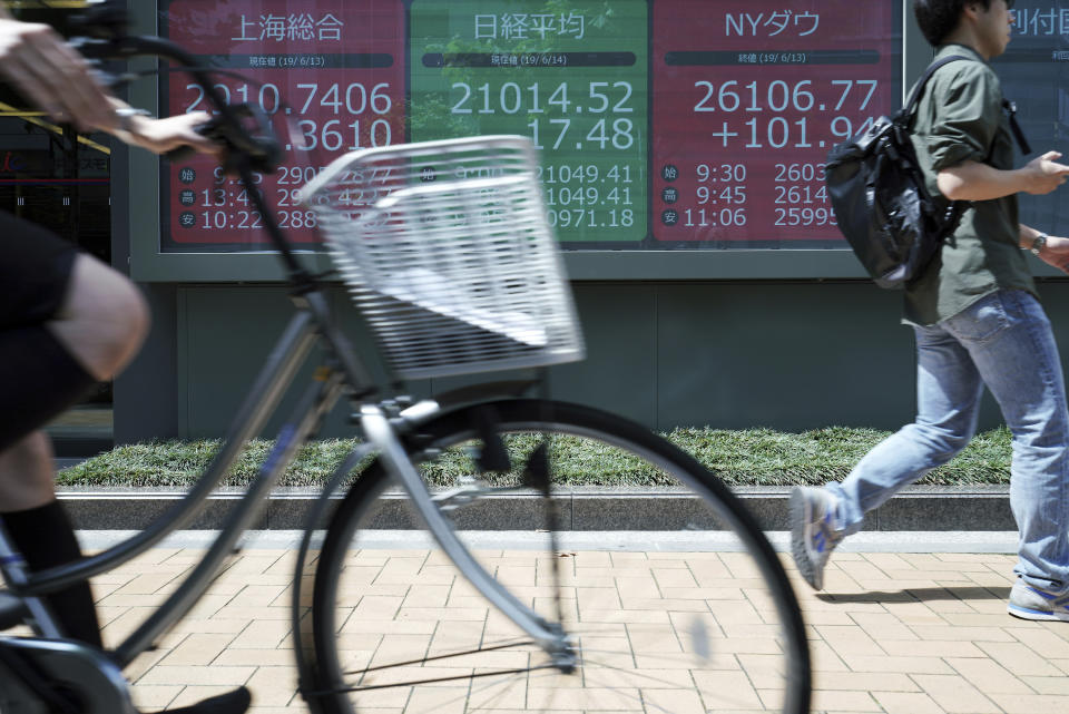 A man walks past an electronic stock board showing Japan's Nikkei 225 index at a securities firm in Tokyo Friday, June 14, 2019. Asian shares were mixed Friday as investors weighed a variety of factors, including suspected attacks on two oil tankers in the strategic Strait of Hormuz and lingering worries about trade conflict between the U.S. and China. (AP Photo/Eugene Hoshiko)