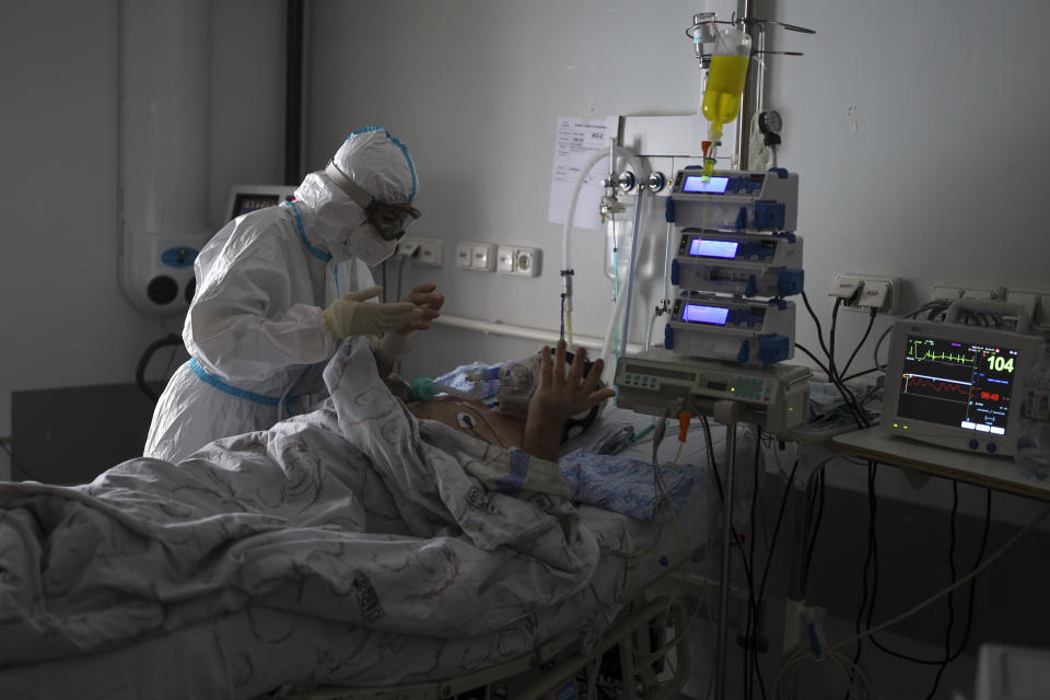 A medical staff member tends to a patient with COVID-19 at an ICU of an hospital in Krasnodar, southern Russia, Thursday, Jan. 27, 2022. Russia has confirmed 11,404,617 cases of coronavirus and 328,770 deaths, according to the national coronavirus information center. Russia's total excess fatality count since the start of the coronavirus pandemic is at least 929,000. Under half the population is fully vaccinated. (AP Photo/Vitaliy Timkiv)