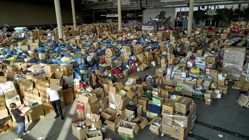 Volunteers sort donations at the donation centre on the Ring Boulevard of Nurburg, Germany, before they are delivered to the flood disaster area, Thursday July 22, 2021. In the flood disaster area of Erftstadt-Blessem, some residents are being allowed back into their homes to clear debris after heavy rains caused devastating floods. (Thomas Frey/dpa via AP)