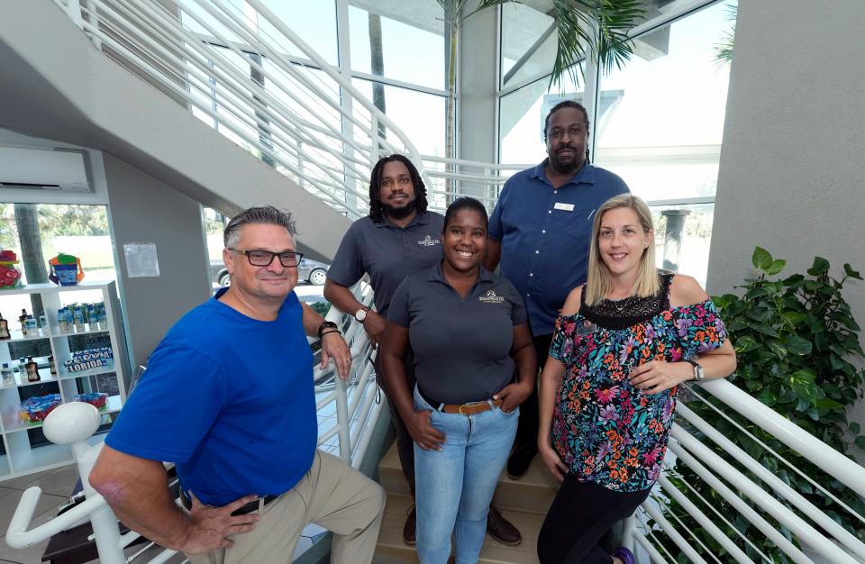 Greg Teagarden, left, general manager of the Boardwalk Inn & Suitesin Daytona Beach, poses with staff members in the hotel's lobby. Under new ownership, the hotel is embarking on a series of renovations to rooms and other features at the hotel.
